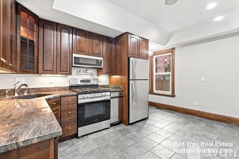 A kitchen with wooden cabinets and a granite countertop.