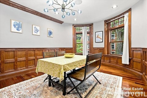 A dining room with a yellow tablecloth and a chandelier.