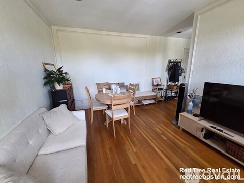 A living room with a white couch and a wooden table.