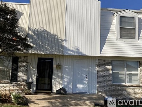 A house with a white door and windows is for sale.