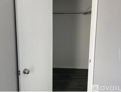 A white door with a silver handle is open.