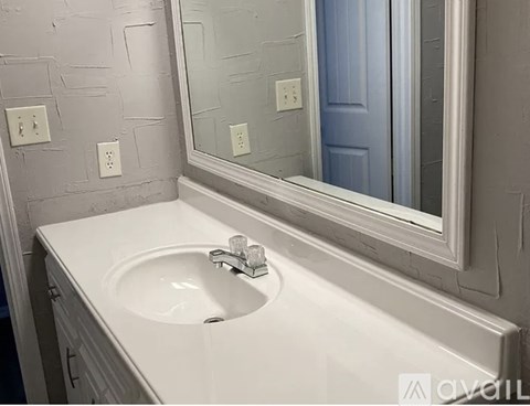 A white sink in a bathroom with a mirror above it.