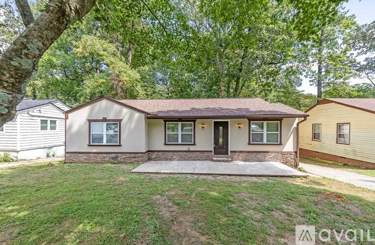 A house with a front yard and a tree in the front.