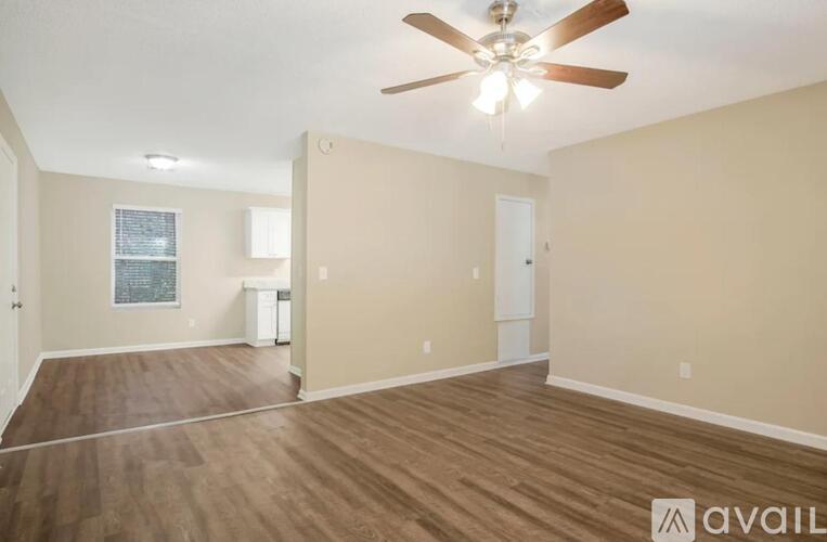 A room with a ceiling fan and wooden flooring.