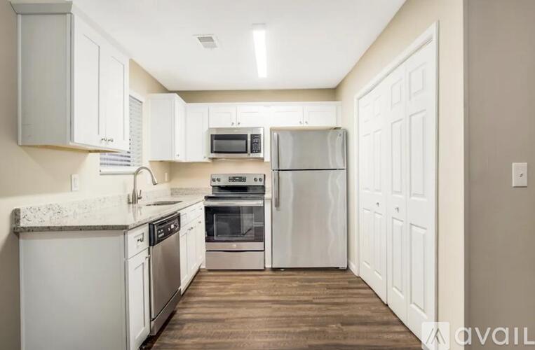 A kitchen with white cabinets and appliances.