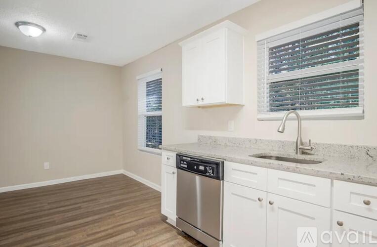 A kitchen with white cabinets and a stainless steel dishwasher.