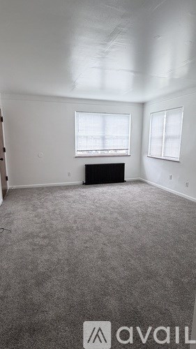 A room with a carpeted floor and a window.