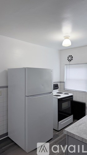 A kitchen with a white fridge and stove top oven.