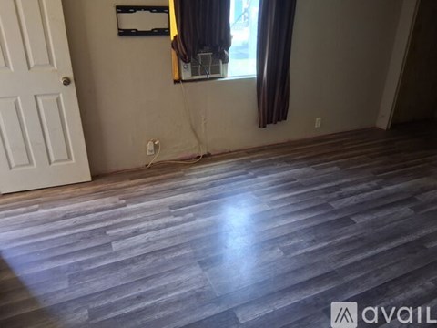 A room with wooden flooring and a white door.