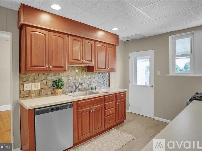 A kitchen with wooden cabinets and a tiled backsplash.