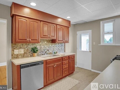 A kitchen with wooden cabinets and a tiled backsplash.