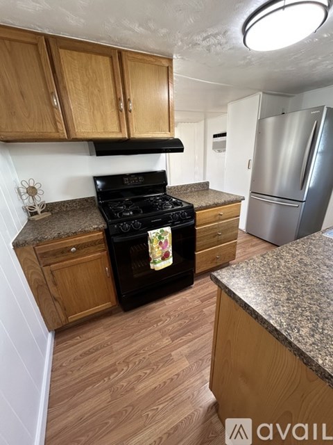 A kitchen with wooden cabinets and a black stove top oven.