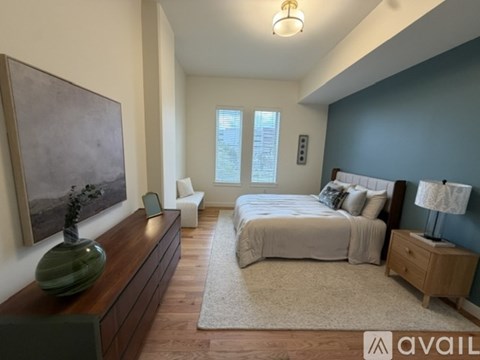 A bedroom with a large bed and a painting on the wall.