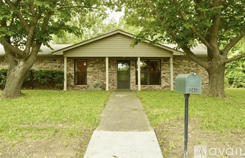 A house with a green lawn and a mailbox with the number 205 on it.