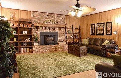 A living room with a fireplace and a ceiling fan.