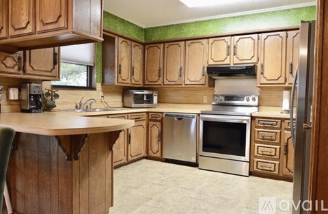 A kitchen with wooden cabinets and stainless steel appliances.