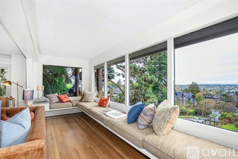 A sunny day in a living room with a view of the city.