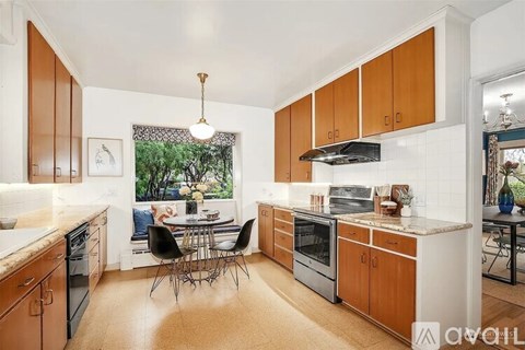 A kitchen with wooden cabinets and a dining table.