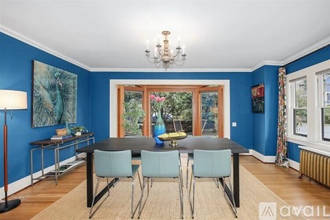 A dining room with a table and chairs.