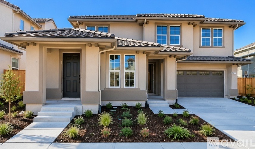 A modern house with a front yard and landscaping.