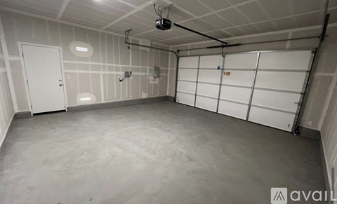 A spacious garage with white walls and a concrete floor.