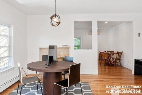 A modern dining room with a round table and chairs.