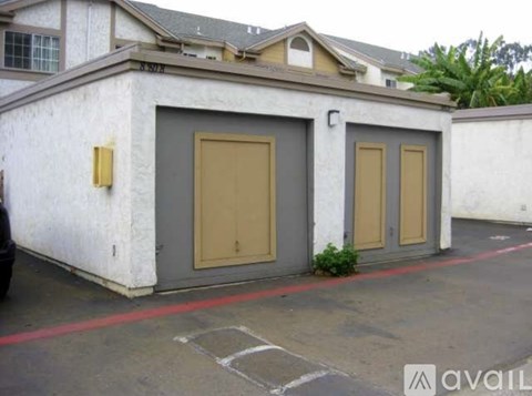 A white building with two brown doors and a red line on the ground.