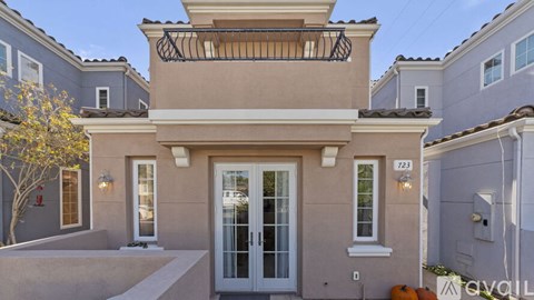 A house with a balcony and a glass door is numbered 723.