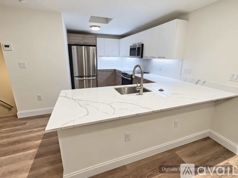 A kitchen with a marble countertop and stainless steel appliances.