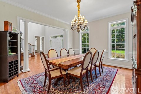 A dining room with a wooden table and chairs.