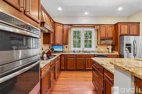 A kitchen with wooden cabinets and a granite countertop.
