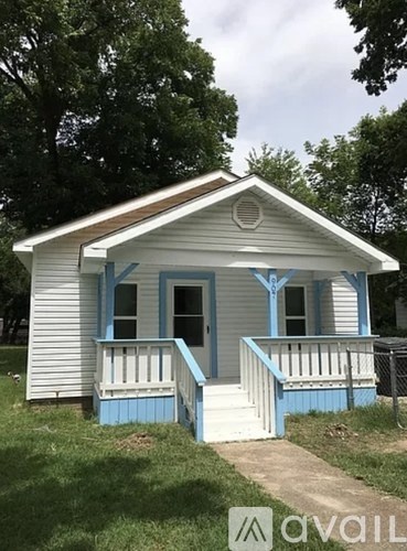 A small blue and white house with a porch.