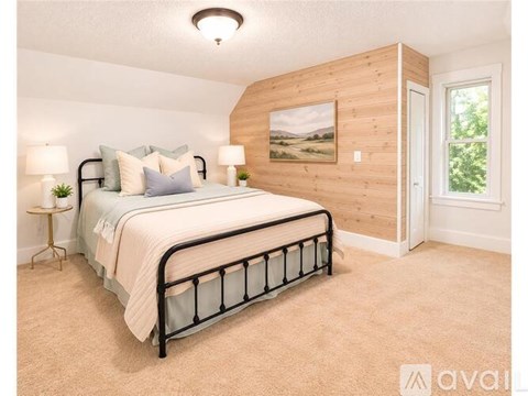 A bedroom with a large bed and a painting on the wall.