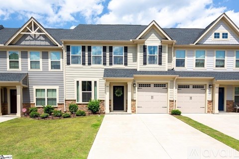 A row of houses with garages and driveways.