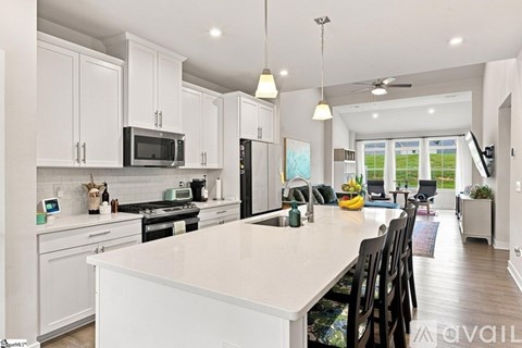 A modern kitchen with white cabinets and a large island.