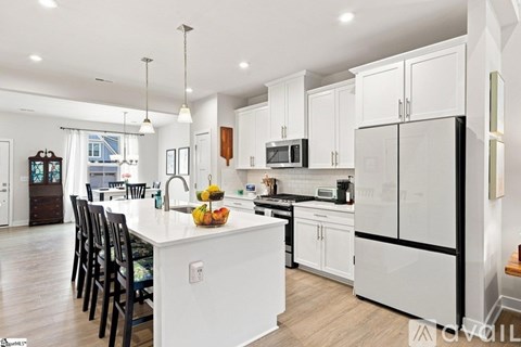 A modern kitchen with white cabinets and a large island.