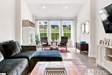 A living room with a black couch and a wooden coffee table.