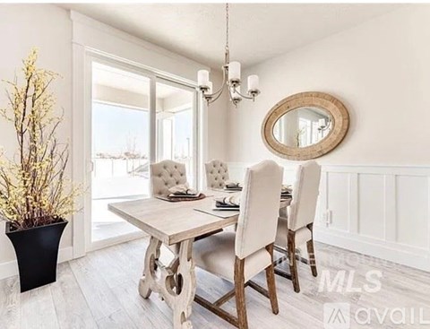 A dining room with a table and chairs and a mirror on the wall.