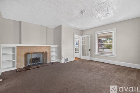 A living room with a fireplace and a carpet.