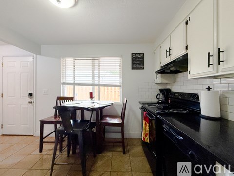 A kitchen with a table and chairs in front of a window.