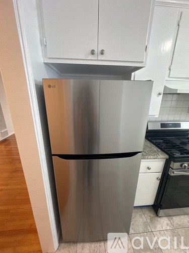 A kitchen with a stove, sink, and refrigerator.