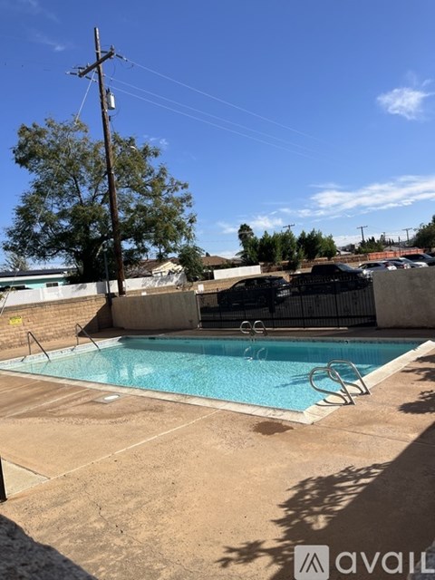A pool with a ladder and a tree in the background.