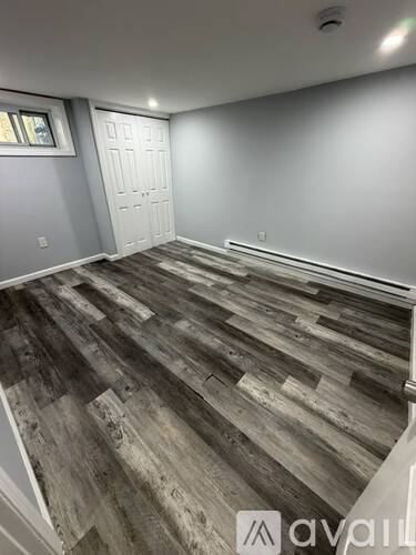 A room with wooden flooring and a white door.