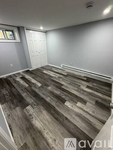 A room with wooden flooring and a white door.