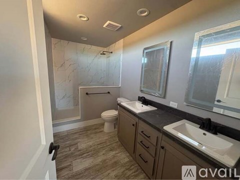 A bathroom with a toilet, sink, and mirror.