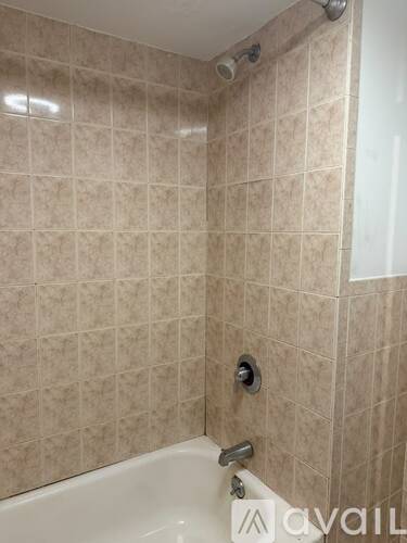 A bathroom with a beige tile shower.