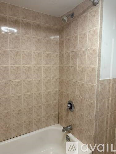 A bathroom with a beige tile shower.