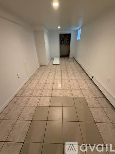 A long hallway with tiled floors and white walls.