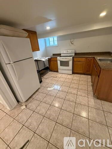 A kitchen with a white refrigerator and wooden cabinets.