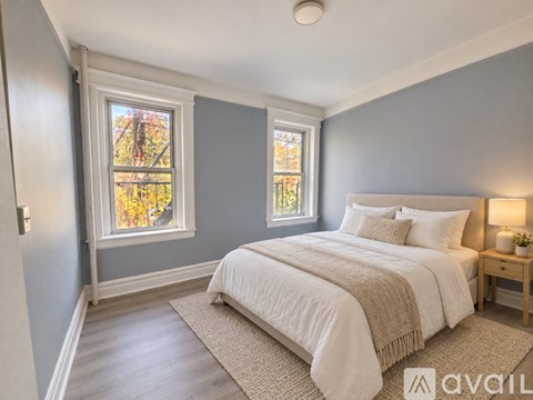 A bedroom with a bed, nightstand, and window.
